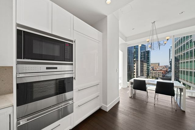 a kitchen with stainless steel appliances a stove a microwave and white cabinets