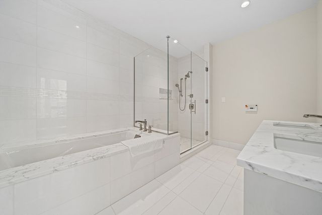 a spacious bathroom with a tub sink and shower