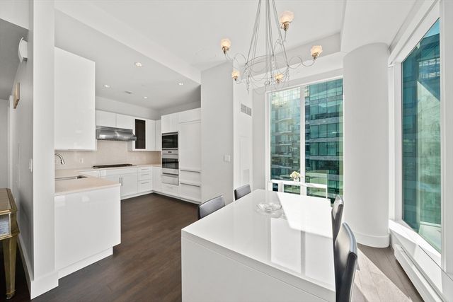 a living room with stainless steel appliances kitchen island furniture and a large window