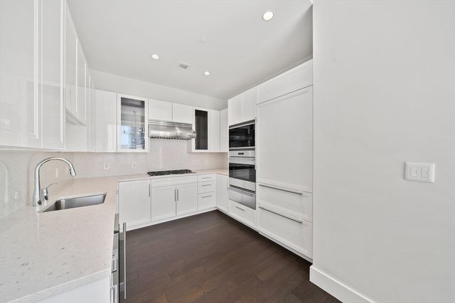 a kitchen with granite countertop white cabinets and white appliances