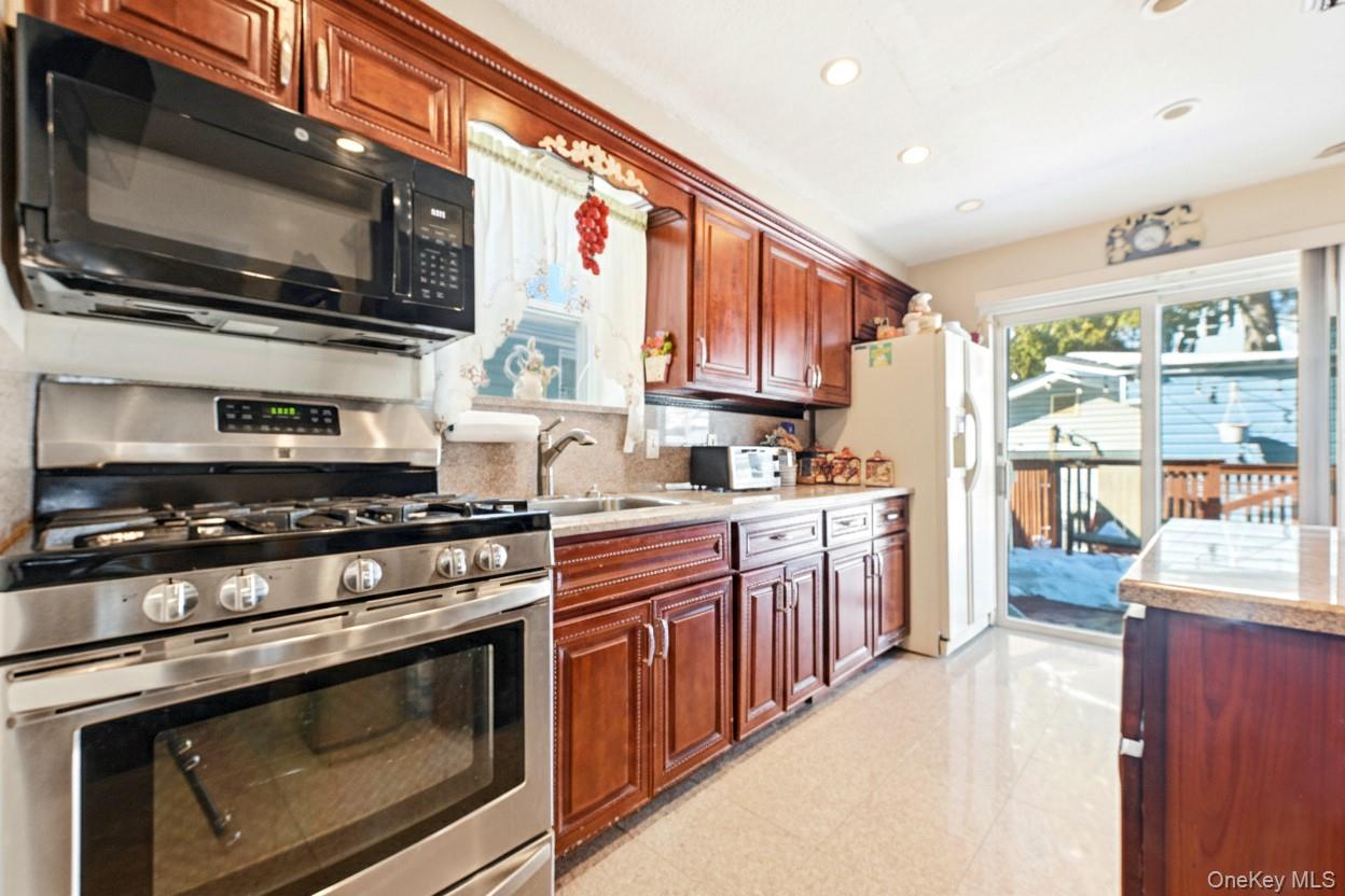 89-18 239th Street Queens, NY 11426 - Photo 5 of 14 a kitchen with stainless steel appliances a stove microwave and sink