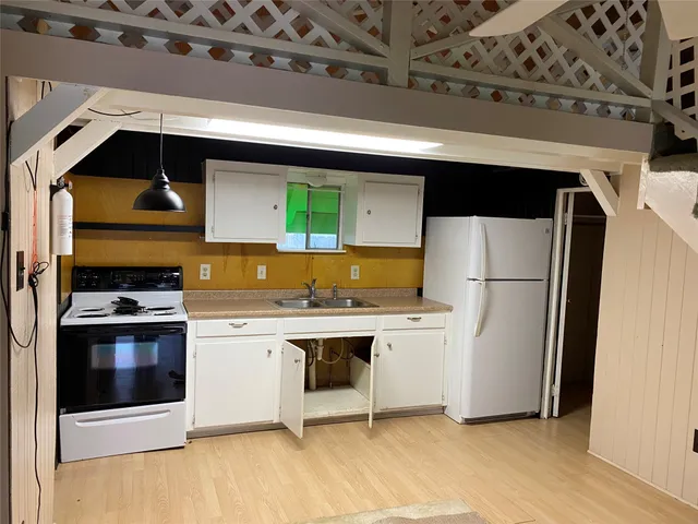 a kitchen with stainless steel appliances a refrigerator a stove and white cabinets