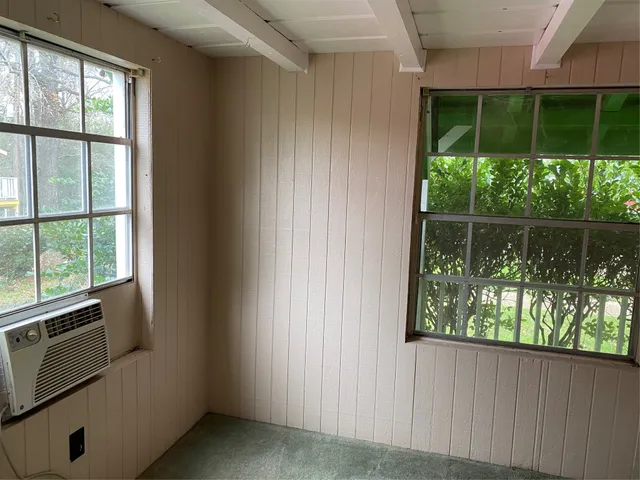 a view of an empty room with a fireplace and a window