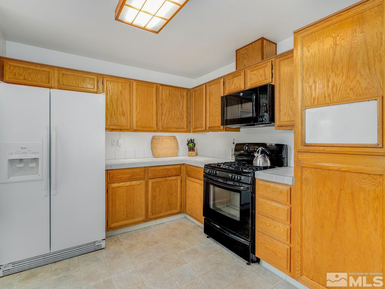 1722 Rainbow Ridge Road Reno, NV 89523 - Photo 11 of 27 a kitchen with stainless steel appliances granite countertop a stove a sink and a refrigerator