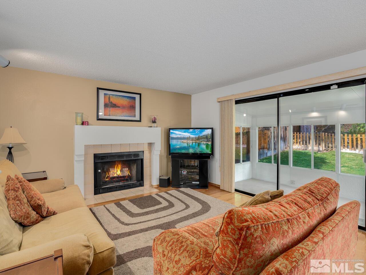 1722 Rainbow Ridge Road Reno, NV 89523 - Photo 7 of 27 a living room with furniture a flat screen tv and a fireplace