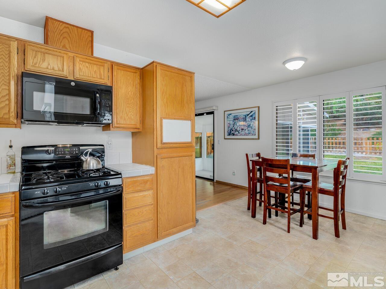 1722 Rainbow Ridge Road Reno, NV 89523 - Photo 10 of 27 a kitchen with stainless steel appliances a stove a sink a microwave and a refrigerator