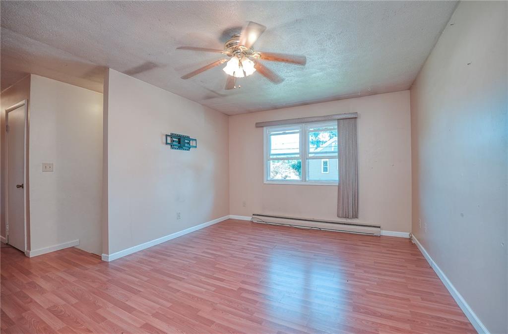 296 East Pike Road Indiana, PA 15701 - Photo 3 of 46 an empty room with wooden floor chandelier fan and windows