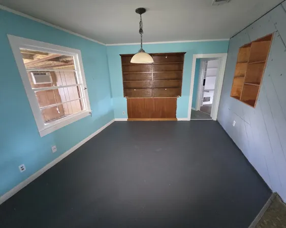a view of a room with wooden floor and windows