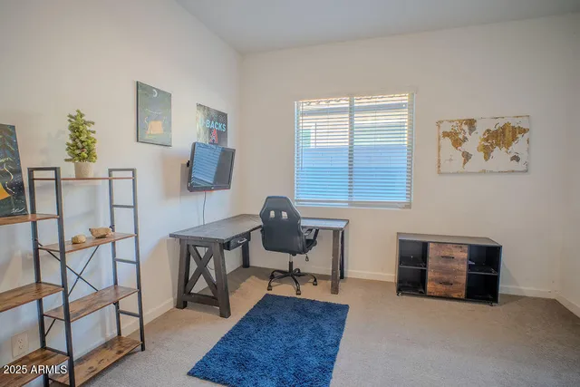 a view of a workspace with furniture and a window