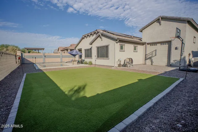 a view of a house with backyard and sitting area