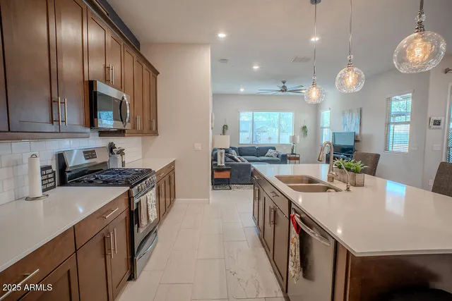 a kitchen with stainless steel appliances granite countertop a sink a stove and a refrigerator