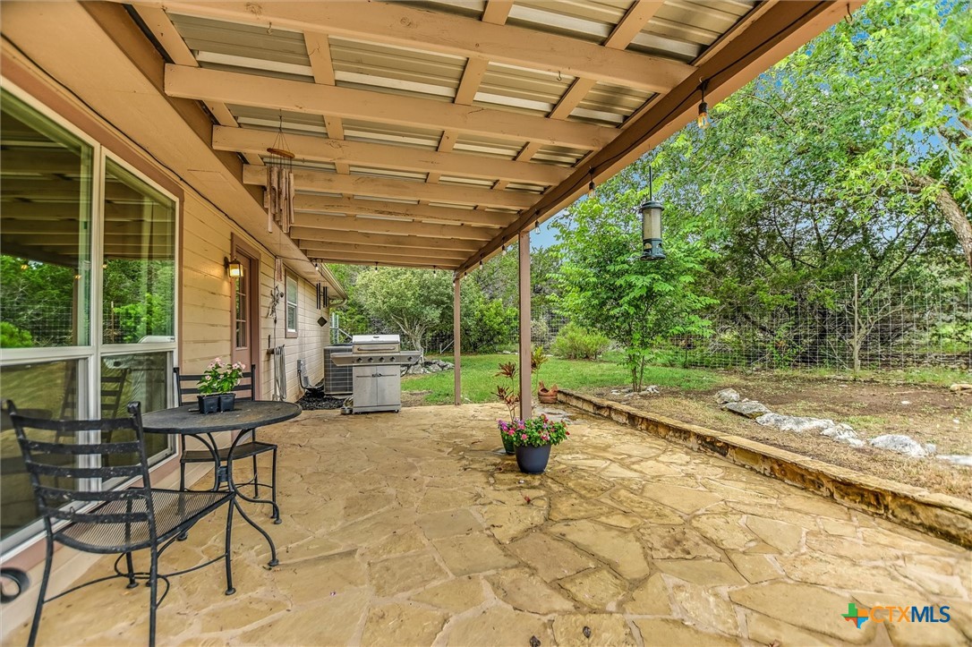 60 Crazy Cross Road Wimberley, TX 78676 - Photo 14 of 20 An inviting covered flagstone patio featuring offers a serene outdoor area.