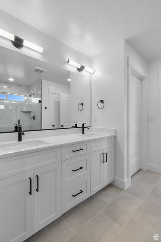 1213 West 500 South Logan, UT 84321 - Photo 16 of 29 Dual vanity with white cabinetry, matte black hardware, and integrated sinks