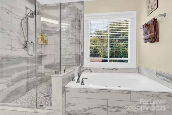 a white bath tub sitting next to a shower