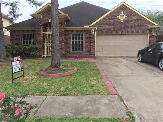 a front view of a house with a yard and potted plants