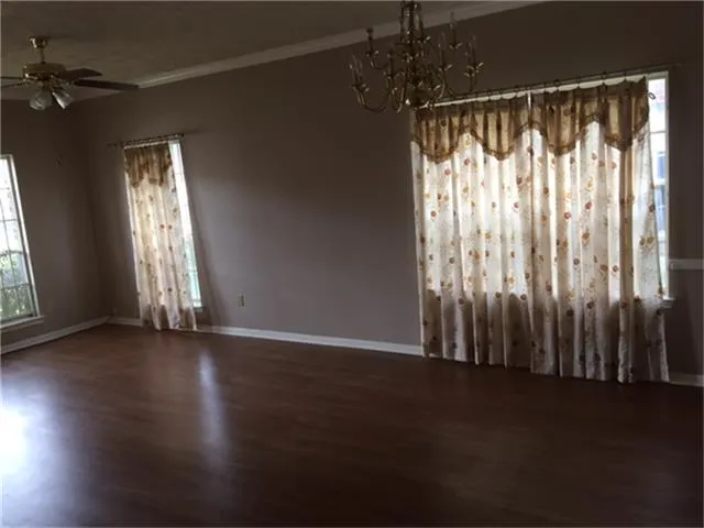 a view of wooden floor and windows in a room