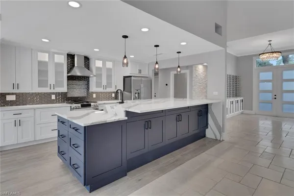 a large kitchen with stainless steel appliances kitchen island granite countertop a sink and cabinets