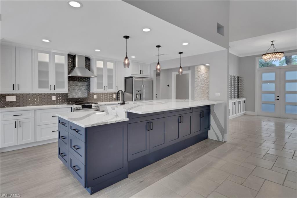 1806 Princess Court Naples, FL 34110 - Photo 12 of 40 a large kitchen with stainless steel appliances kitchen island granite countertop a sink and cabinets