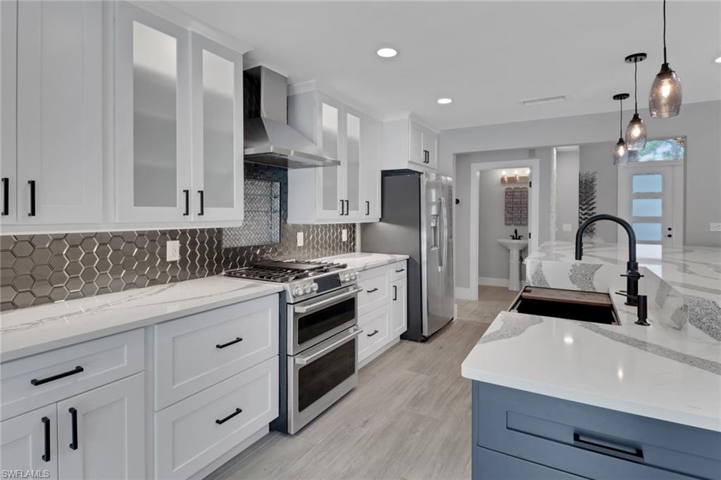 1806 Princess Court Naples, FL 34110 - Photo 13 of 40 a kitchen with stainless steel appliances a sink stove and refrigerator