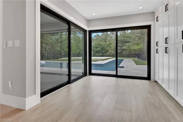 a view of an empty room with wooden floor and door