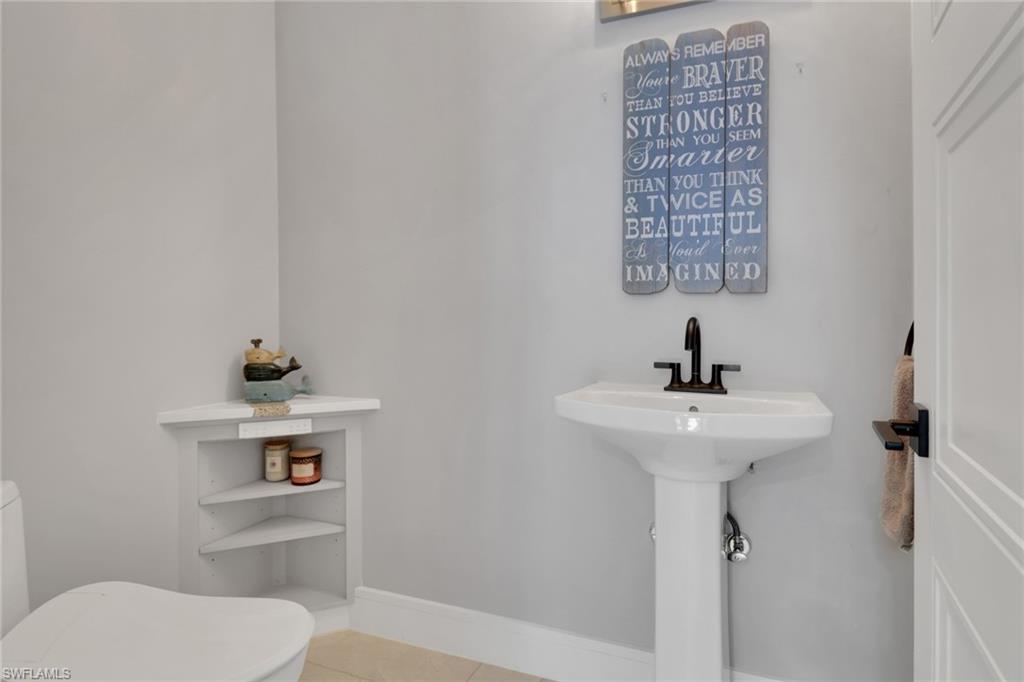 1806 Princess Court Naples, FL 34110 - Photo 16 of 40 a bathroom with a sink a toilet and mirror