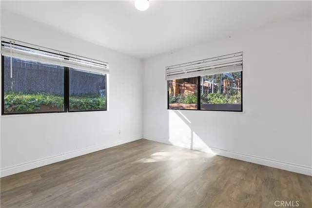 an empty room with wooden floor and a window