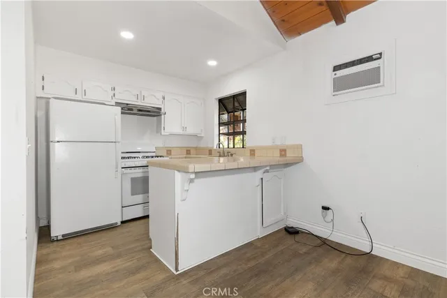 a kitchen with white cabinets and white appliances