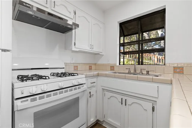 a kitchen with cabinets appliances a sink and a window