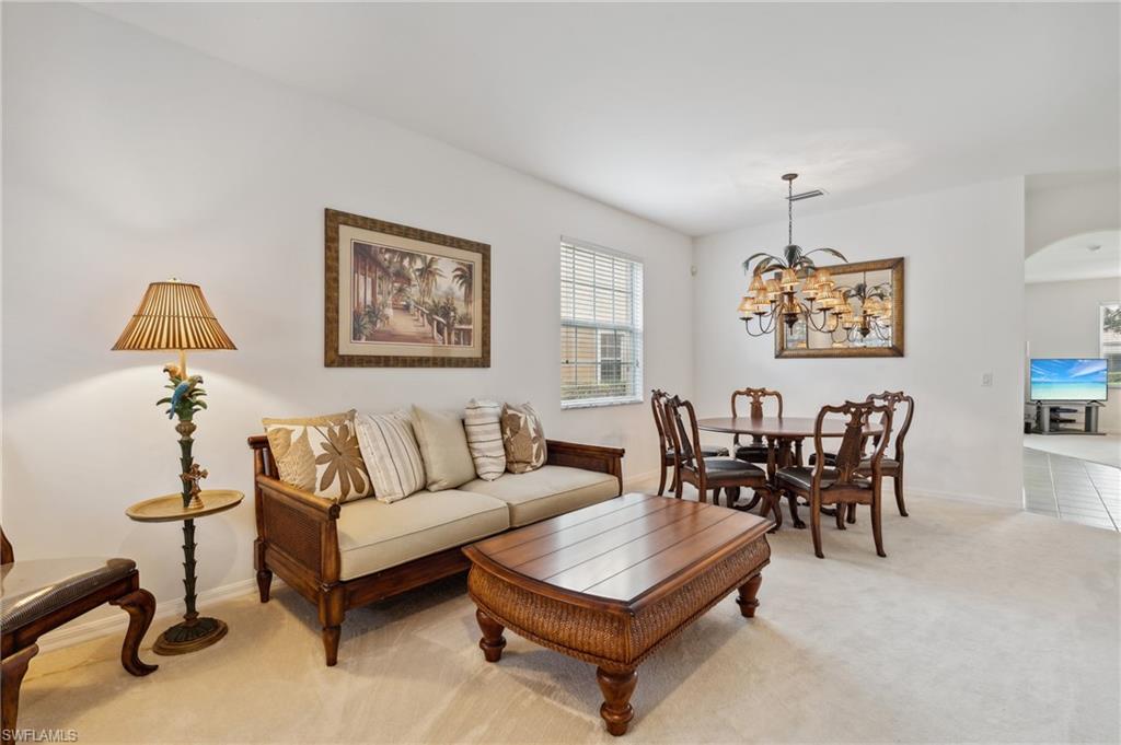 a living room with furniture a window and a lamp