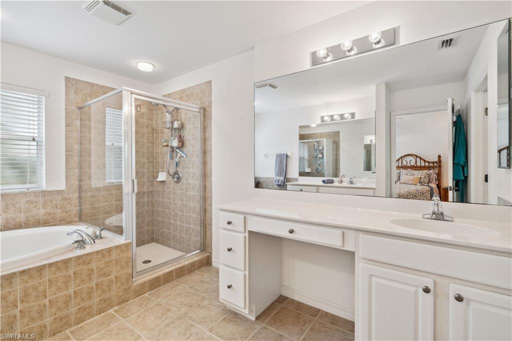 20048 Heatherstone Way, Unit 1 Estero, FL 33928 - Photo 14 of 20 a spacious bathroom with a tub sink shower and mirror
