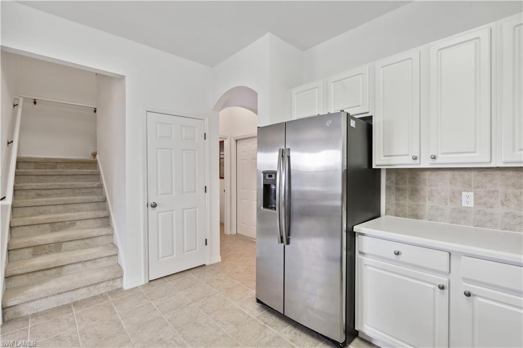 20048 Heatherstone Way, Unit 1 Estero, FL 33928 - Photo 5 of 20 a kitchen with white cabinets and stainless steel appliances