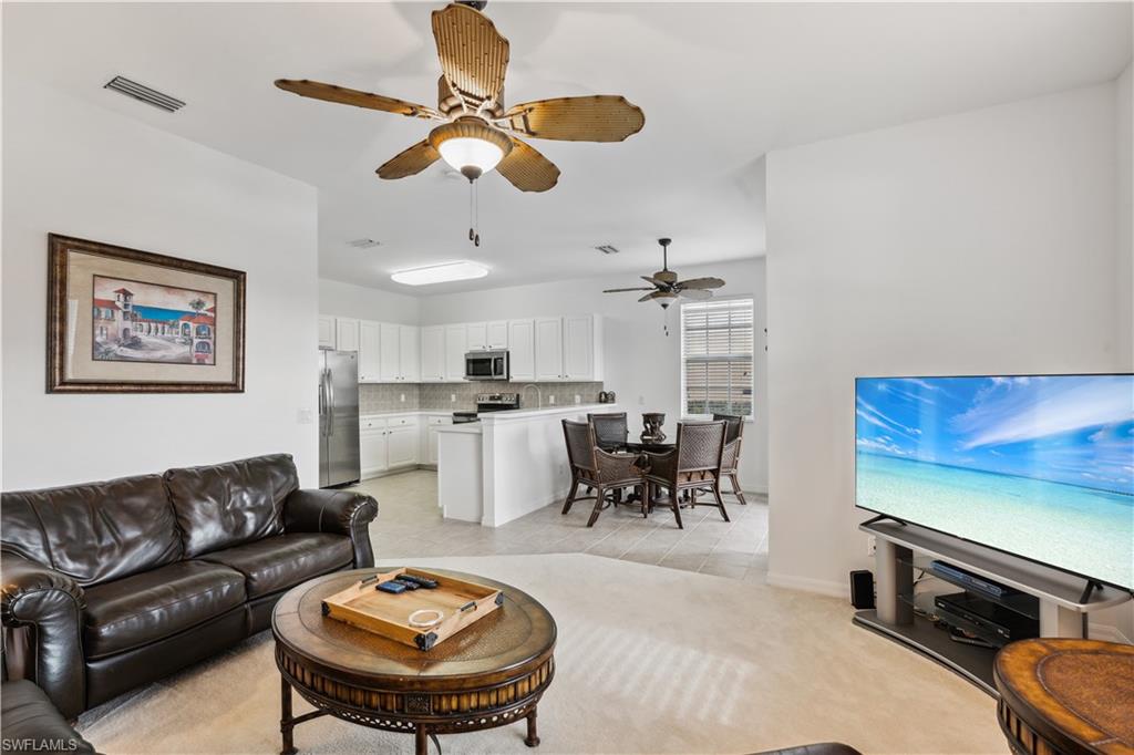 20048 Heatherstone Way, Unit 1 Estero, FL 33928 - Photo 6 of 20 a living room with furniture kitchen view and a flat screen tv