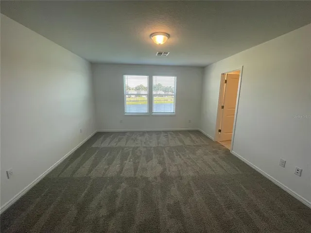 an empty room with staircase and mirror