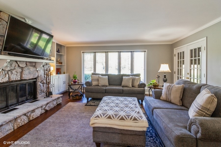 907 Powers Road Woodstock, IL 60098 - Photo 12 of 21 a living room with furniture a flat screen tv and a fireplace