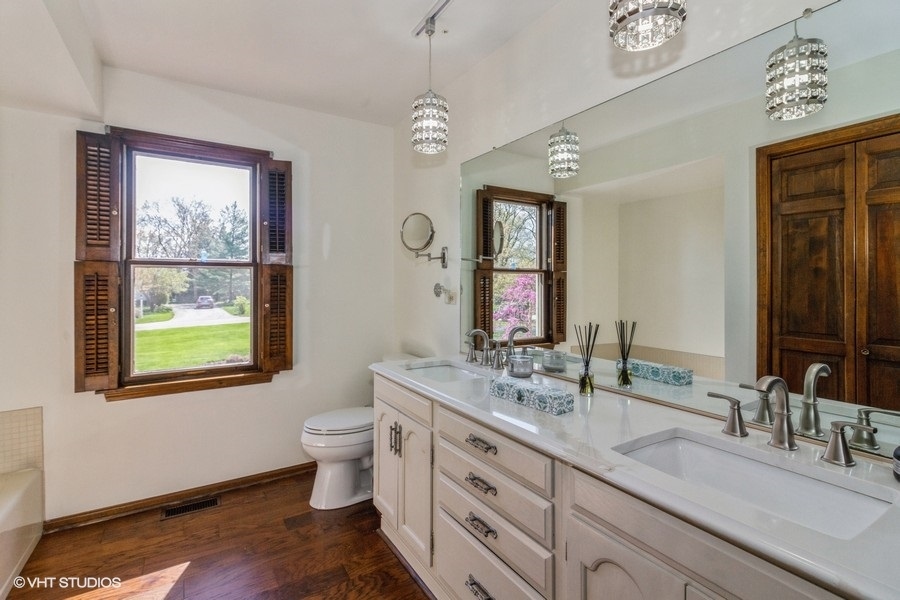 907 Powers Road Woodstock, IL 60098 - Photo 15 of 21 a bathroom with a double vanity sink toilet and a window