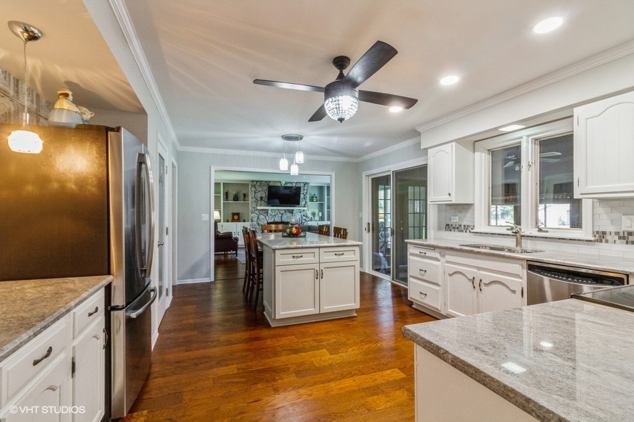 907 Powers Road Woodstock, IL 60098 - Photo 10 of 21 a kitchen with stainless steel appliances granite countertop hardwood floor sink stove and refrigerator