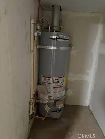 a room with water heater and racks on wall
