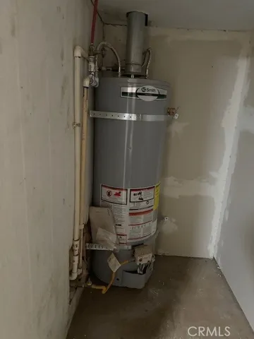 a room with water heater and racks on wall