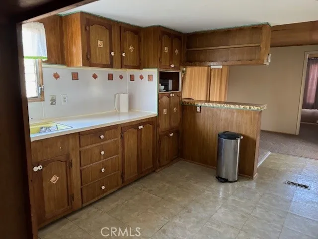 a kitchen with cabinets and wooden floor