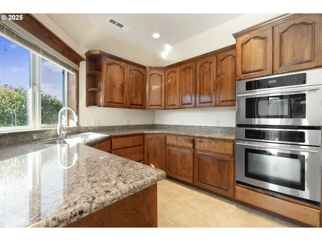 a kitchen with stainless steel appliances granite countertop a sink stove and microwave