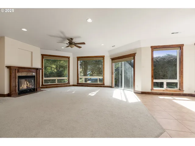 a view of an empty room with a window and a fireplace
