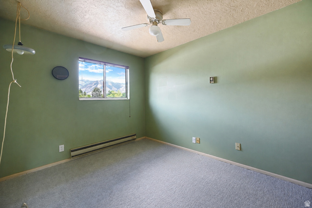 285 West 600 North, Unit 2 Logan, UT 84321 - Photo 14 of 21 Room featuring a window with mountain scenery, wall-to-wall carpeting, and a ceiling fan