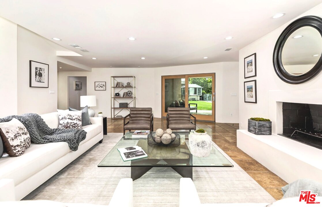 2205 Stradella Road Los Angeles, CA 90077 - Photo 13 of 53 a living room with furniture a fireplace and a table