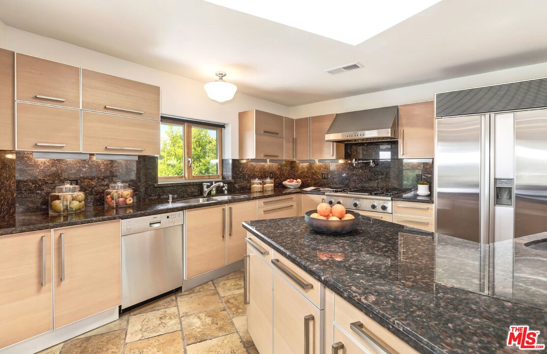2205 Stradella Road Los Angeles, CA 90077 - Photo 15 of 53 a kitchen with granite countertop a sink and a refrigerator