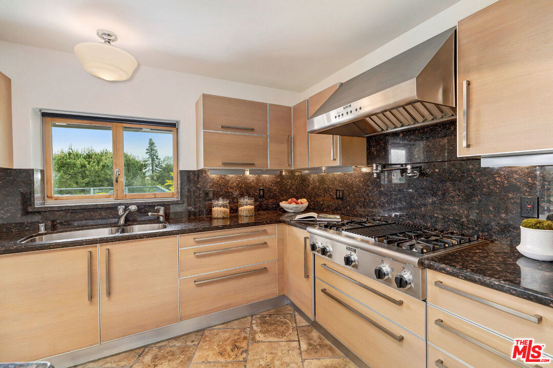 2205 Stradella Road Los Angeles, CA 90077 - Photo 16 of 53 a kitchen with granite countertop a sink stove and cabinets