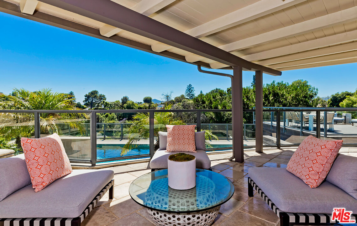 2205 Stradella Road Los Angeles, CA 90077 - Photo 20 of 53 a view of a patio with couches chairs dining table and chairs
