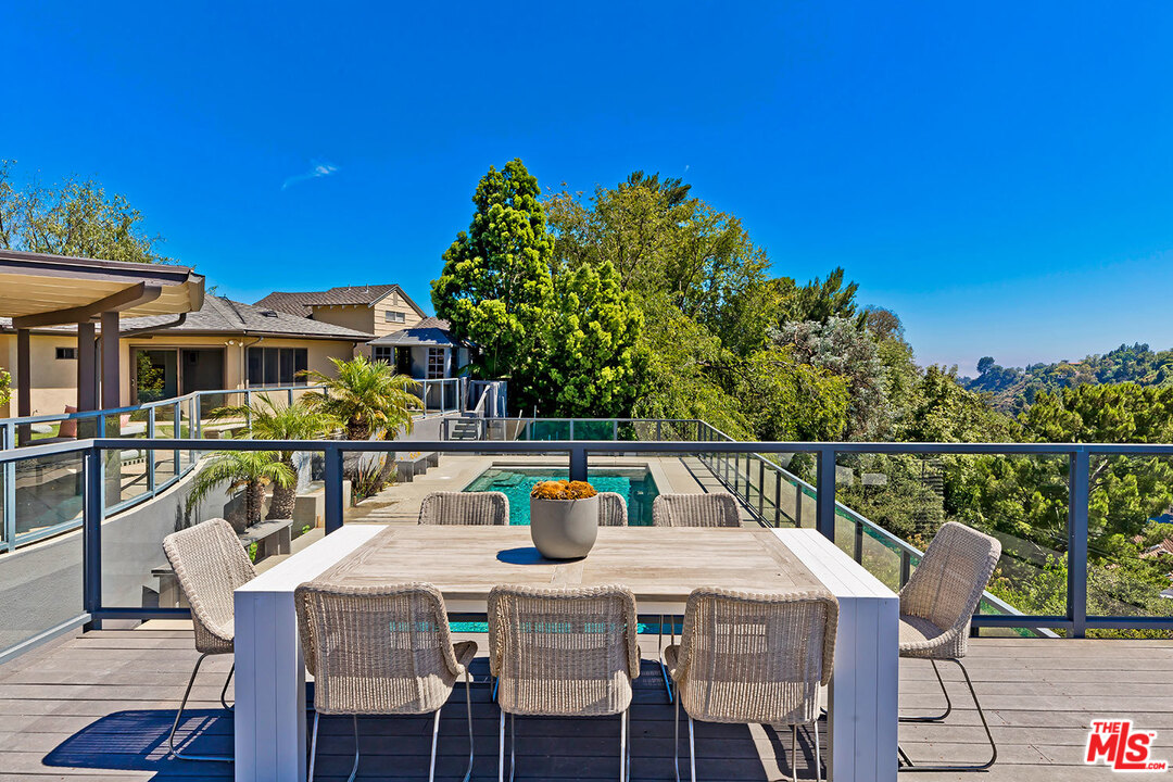 2205 Stradella Road Los Angeles, CA 90077 - Photo 21 of 53 a balcony with wooden floor table and chairs
