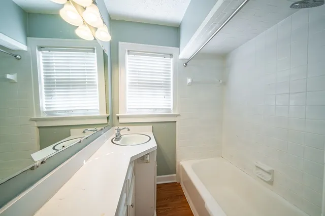 a bathroom with a tub a sink and a window