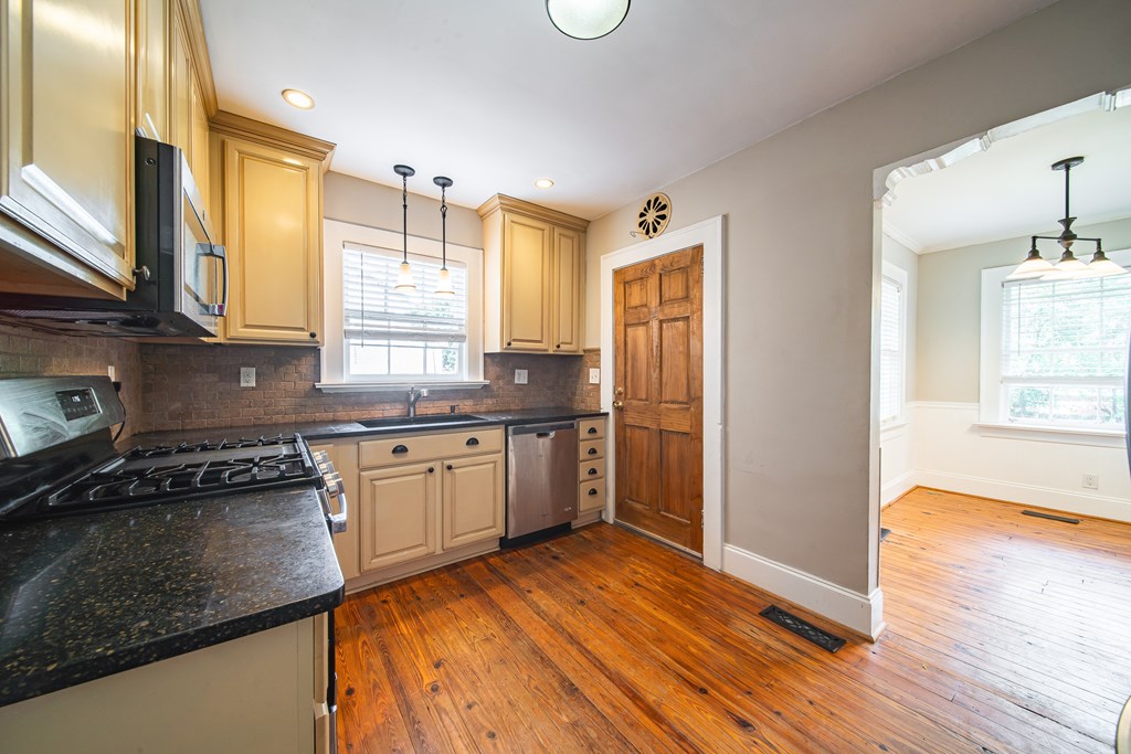 1705 Slade Drive Columbus, GA 31901 - Photo 10 of 37 a kitchen with granite countertop wooden floors appliances and cabinets