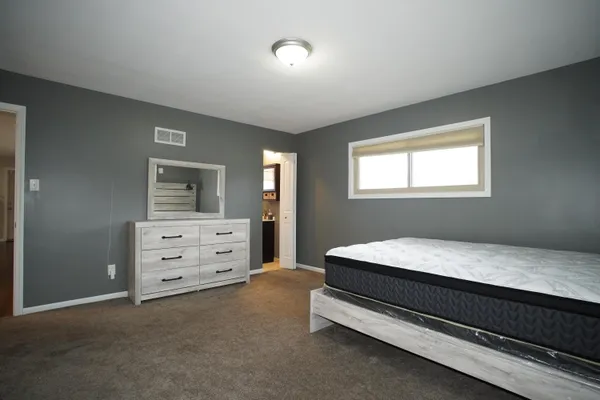 a bed room with a bed and a dresser